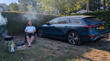 Auto Express head of digital content Steve Walker sitting between the Audi A6 Avant e-tron and a barbecue