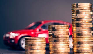 Pile of coins in front of a toy car