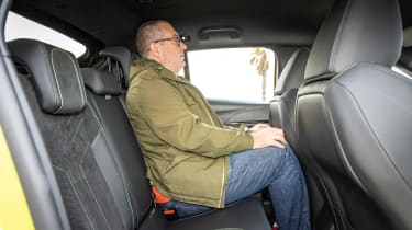 Auto Express editor-at-large John McIlroy sitting in the Peugeot E-208&#039;s back seat