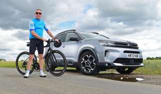 Auto Express senior photographer Pete Gibson standing with a bicycle next to the Citroen C5 Aircross