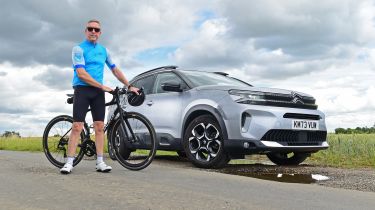 Auto Express senior photographer Pete Gibson standing with a bicycle next to the Citroen C5 Aircross