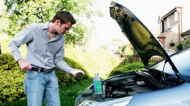 Person checking their car&#039;s oil level