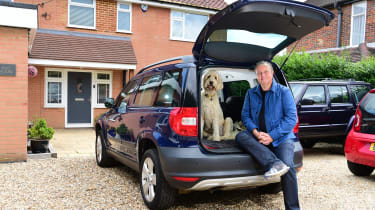 Auto Express editor-in-chief Steve Fowler sitting with his dog in the boot of a Skoda Yeti