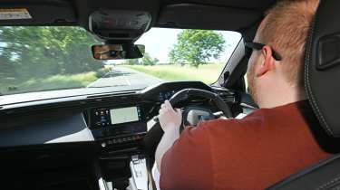 Auto Express news reporter Ellis Hyde driving the Peugeot E-408