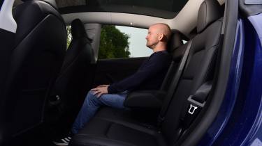 Tesla Model Y - rear seats being sat in by Auto Express chief reviewer Alex Ingram 