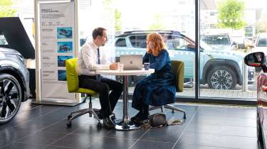 Auto Express pictures editor Dawn Grant and Renault sales executive Jamie Collis sitting inside a Renault showroom