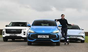 Auto Express consumer reporter Tom Jervis standing by a selection of Chinese cars