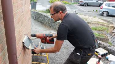 Pod Point technician drilling holes into a wall