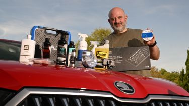 Auto Express products editor Tom Barnard standing with a selection of award-winning car care products