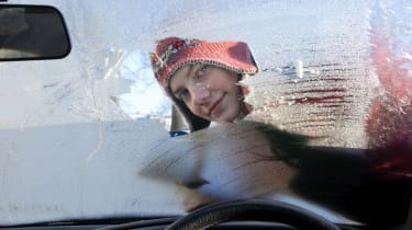 Person scraping ice off of windscreen