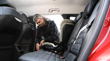 Auto Express deputy editor Richard Ingram fitting a child seat into the Citroen e-C5 Aircross