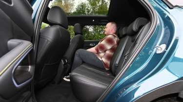 Auto Express news reporter Ellis Hyde sitting in the BYD Atto 2 DM-i's back seat