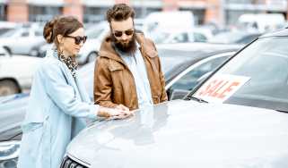 Two people inspecting a car