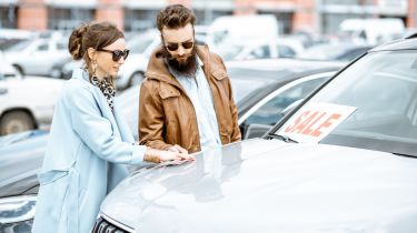 Two people inspecting a car