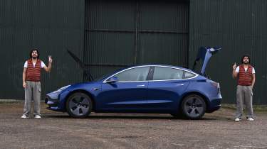 Auto Express senior staff writer Jordan Katsianis standing next to the front and rear of the Tesla Model 3