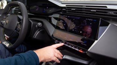 Auto Express editor-at-large John McIlroy operating the Peugeot E-308 SW&#039;s infotainment system