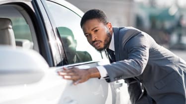 Homme vérifiant la voiture chez le concessionnaire