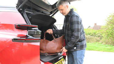 Auto Express deputy editor Richard Ingram loading a bag into the Citroen e-C5 Aircross