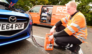 RAC breakdown mechanic charging a battery