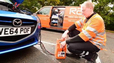 RAC breakdown mechanic charging a battery