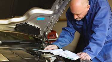 Technician filling out a car's service book