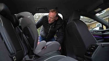 Volkswagen ID.7 Tourer - rear seats with Auto Express’ editor-at-large, Phil McNamara installing a child seat