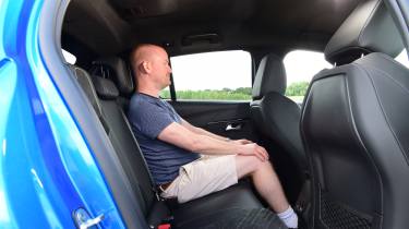 Peugeot E-208 - rear seats being sat in by Auto Express chief reviewer Alex Ingram