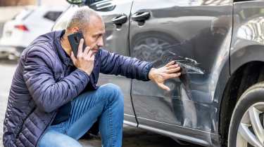 Person inspecting bodywork damage