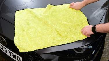 Auto Express contributor Tom Barnard drying the Mazda 3&#039;s bonnet