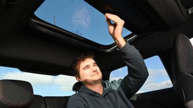 Auto Express senior news reporter Alastair Crooks operating the MINI Cooper JCW's sunroof