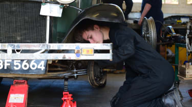 Student mechanic inspecting classic car