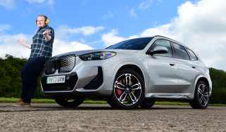 Auto Express news reporter Ellis Hyde leaning against the BMW iX1