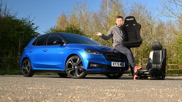 Skoda Fabia 130 long-term test - Senior news reporter Alastair Crooks sat on the bonnet of the Skoda holding a racing car seat