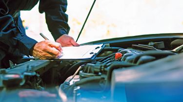 Mechanic inspecting a car&#039;s engine bay