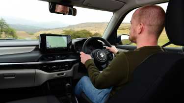 Auto Express chief reviewer Alex Ingram driving the Suzuki Swift