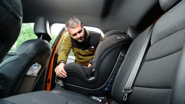 Carbuyer and DrivingElectric editor Richard Ingram fitting a child&#039;s car seat to the MG4&#039;s back seat