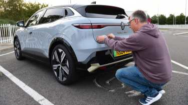 Auto Express editor Paul Barker putting a &#039;UK&#039; sticker on the Renault Megane E-Tech