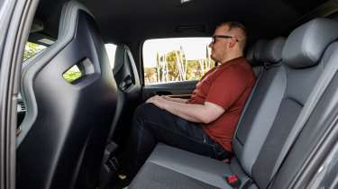 Cupra Born facelift - rear seats being sat in by Auto Express news reporter Ellis Hyde