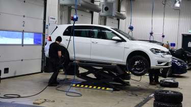 Volkswagen Golf winter tyre testing car on a workshop inspection ramp