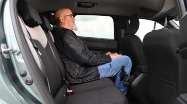 Dacia Duster Hybrid - rear seats being sat in by Auto Express senior test editor Dean Gibson