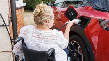 Person in wheelchair plugging in car Alistair Veryard photography
