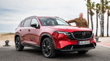 Auto Express news reporter Ellis Hyde standing next to a Mazda CX-5