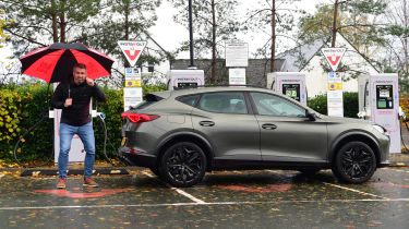 Auto Express deputy editor Richard Ingram standing with the Cupra Formentor in front of an array of Instavolt chargers