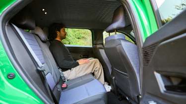 Renault 5 - rear seats being sat in by Auto Express senior staff writer Jordan Katsianis 