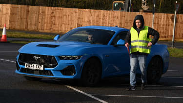 Auto Express chief reviewer Alex Ingram standing next to a Ford Mustang