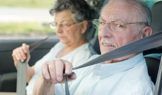old couple putting on seatbelts