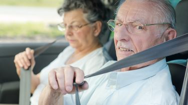 old couple putting on seatbelts