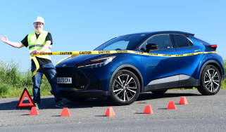 Auto Express commercial editor Paul Adam standing next to the Toyota C-HR while wearing a hard hat and high-vis jacket