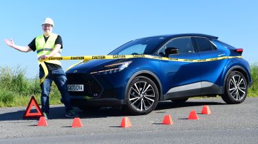 Auto Express commercial editor Paul Adam standing next to the Toyota C-HR while wearing a hard hat and high-vis jacket