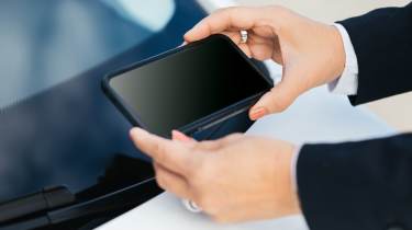 Mobile phone being used to photograph a car